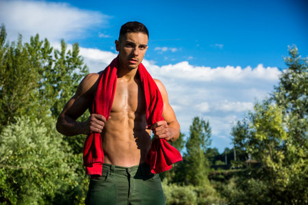 Photo of a shirtless man with a red towel around his neckの写真素材