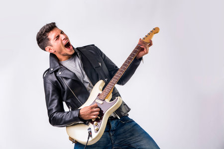 A man in a leather jacket playing a guitarの写真素材