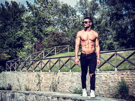 A shirtless man walking down a stone walkwayの写真素材