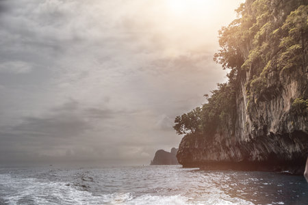 A large body of water next to a rocky cliff. Photo of a stunning coastal landscape with a rocky...