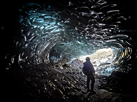 man exploring an ice cave in Icelandの写真素材