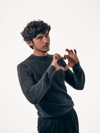A man making a heart with his hands, in studio shot on neutral background