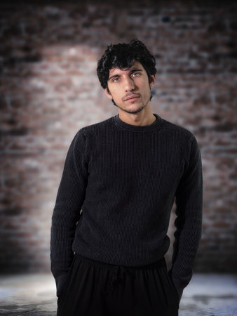 A man standing in front of a brick wall