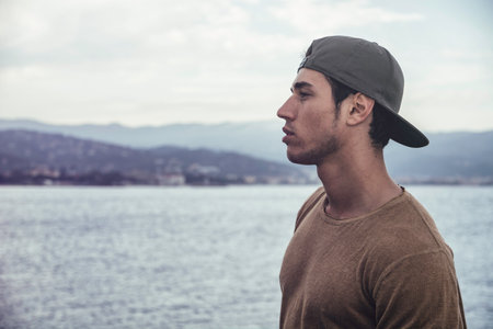 A man standing in front of a body of waterの写真素材