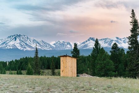 Outdoor toilet in the snowy mountains of Altai at sunsetの写真素材