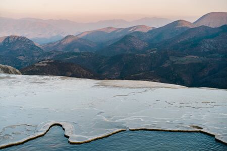 Girl on top of a white mountain with blue lakes and springs in Mexico hierve del agua