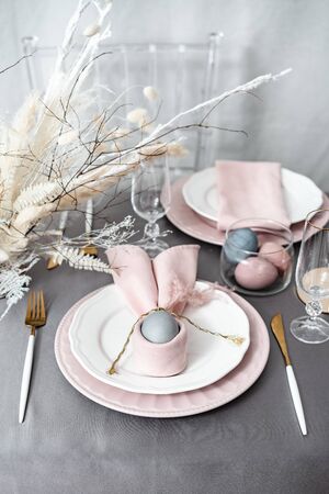 Setting Easter table with colored eggs