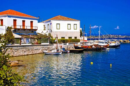 Greece, Saronic gulf, Spetses island, fishing boats in front of traditional houses in the old...