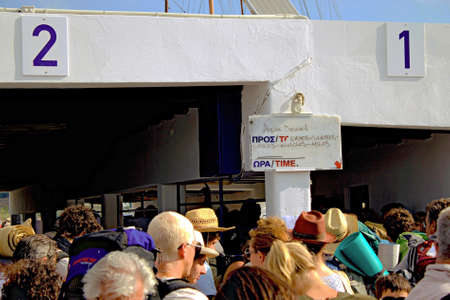 Greece, Paros island, port of Paroikia, passengers embarking to ferry boat with Piraeus port as...