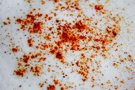 Close up of cinnamon on cappuccino coffee cream.