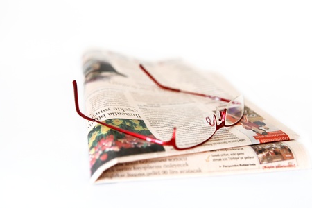 Glasses on the newspaper white backgroundの写真素材