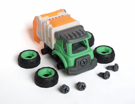 front view of plastic garbage truck toy with bolt and screwdriver isolated on white background, DIY assemble toy for increasing kid's creativity. with copyspace for bannerの写真素材