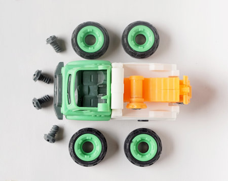 Top view of plastic towing truck toy with bolt and screwdriver isolated on white background, DIY...