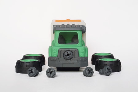 front view of plastic garbage truck toy with bolt and screwdriver isolated on white background, DIY assemble toy for increasing kid's creativity.の写真素材