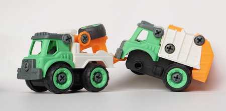 DIY plastic truck toy isolated on white. Heavy duty truck towing damaged garbage truck. DIY assemble toy for increasing kid's creativity.の写真素材