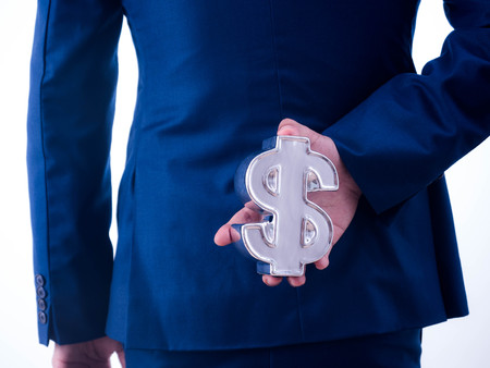 Young businessman holding a financial symbol on the back isolated on white background.の写真素材
