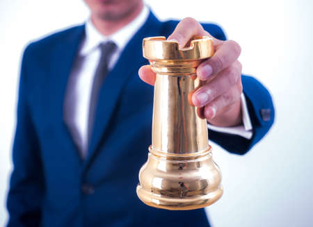 Business strategy and leadership concept - Businessman holds a chess symbol of the leader.の写真素材