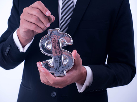 Saving, male hand putting a coin into financial symbol  bank.の写真素材