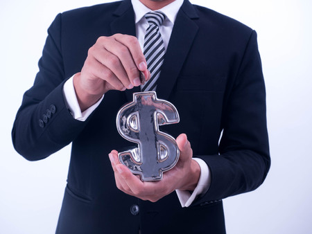Saving, male hand putting a coin into financial symbol  bank.の写真素材
