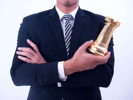 Business strategy and leadership concept - Businessman holds a chess symbol of the leader.の写真素材