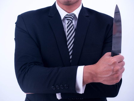 Young businessman holding knife isolated from a white background.の写真素材