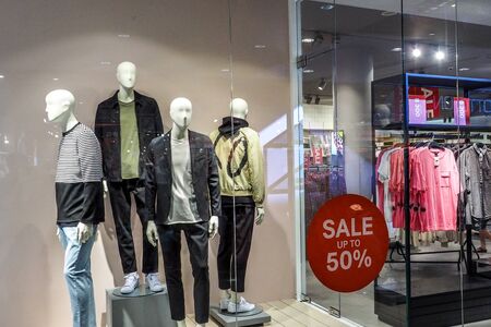 BANGKOK THAILAND, April 4, 2017: Large red Sale letters on a glass wall obstruct a view inside the popular clothing H & M store.のeditorial素材