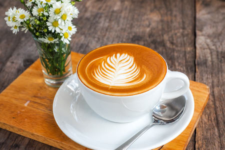 Coffee cup on a wooden table and a Little flower.の写真素材