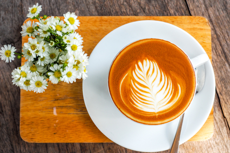 Coffee cup on a wooden table and a Little flower.の写真素材