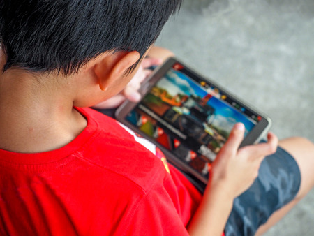 Kid playing games on mobile phone.の写真素材