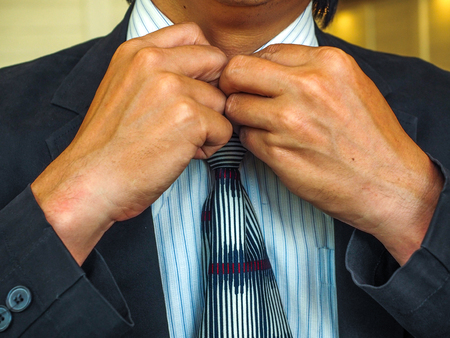 Business Man fixing his suitの写真素材