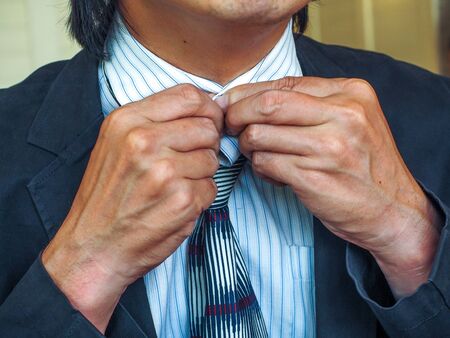 Business Man fixing his suitの写真素材