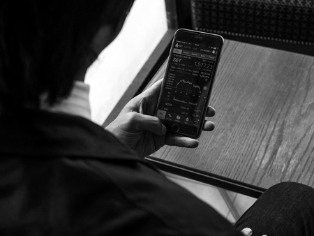 BANGKOK, THAILAND - April 18, 2017 : Businessman buying Thai Stock Exchange Market  Forex Trade Investment Fund Graph on Smartphone.のeditorial素材