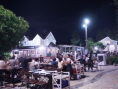 Blurred and bokeh outdoor restaurant and water in the pond at night backgroundの写真素材