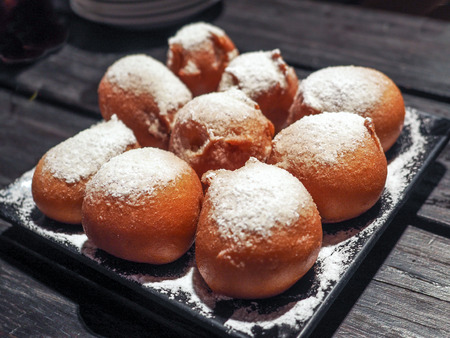 close up fried banana ball dessert with wood stick on dish and wood table for surveの写真素材