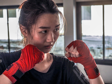 Young attractive asian woman with boxing gloves are ready for battle.