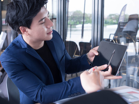 creative young in a business suit with a tie and show display a tablet.の写真素材