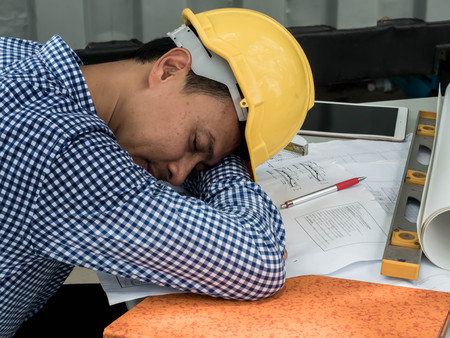 Engineer sleeps on the table while working.の写真素材