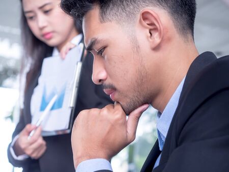 Tired businessman at desk with laptop searching way out from difficult situation. Thoughtful stressed frustrated man working for too long on computer, chooses solution, thinking about hard problemの写真素材