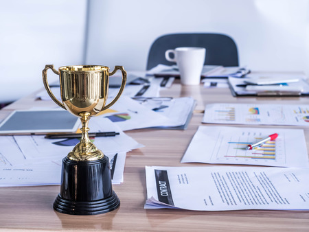 Award trophy on working table with document and contract
