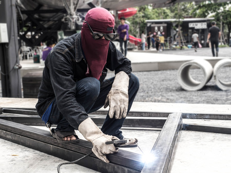 Worker welding parts of stell construction