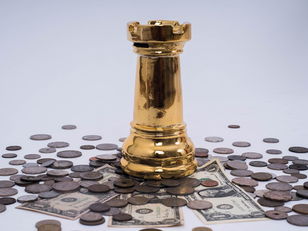 Business success concept, Dollar banknotes and Foreign currency coins with chess symbol of the leader.の写真素材