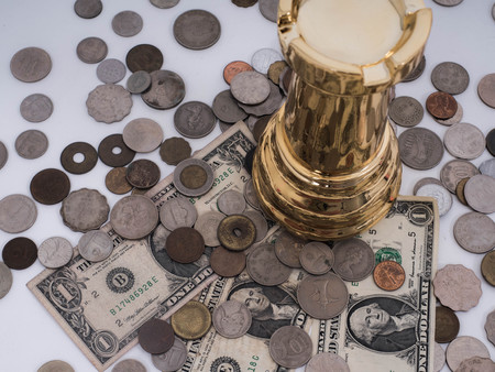 Business success concept, Dollar banknotes and 
Foreign currency coins with chess symbol of the leader.の写真素材