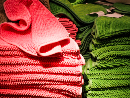 pink and green Stack of bath towels on light in store closeup