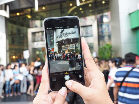 someone taking photo with phone facade Platinum Fashion Mallのeditorial素材