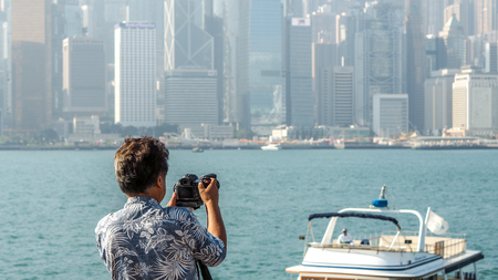 HONG KONG - DECEMBER 10,2016:Tourists take pictures and enjoy the famous Hong Kong island skyline across Victoria Harbour from the avenue of stars in Kowloon.のeditorial素材