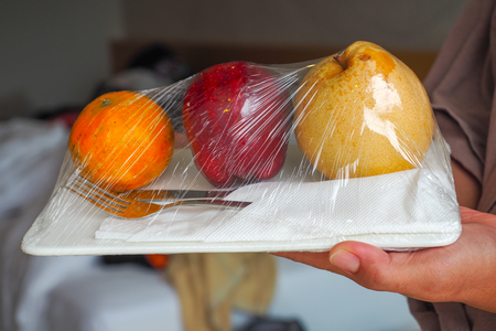 welcome fruit in hotel room with pear apple and orange ready to eat with silver knife and forkの写真素材
