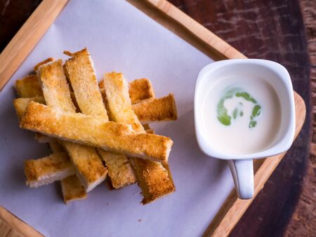 Slice bread and custard, on wood dish, isolate.Custard bread.の写真素材