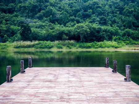 View of lake from dock with trees in backgroundの写真素材