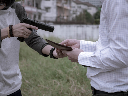 A murderer, Terrorist attacking holding gun kidnapping business young man for a hostage robbery and...