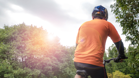 Man ride a bicycle on an off road to the sunsetの写真素材
